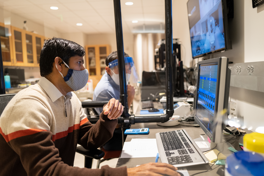 UMass researchers who are wearing facemasks working on computers